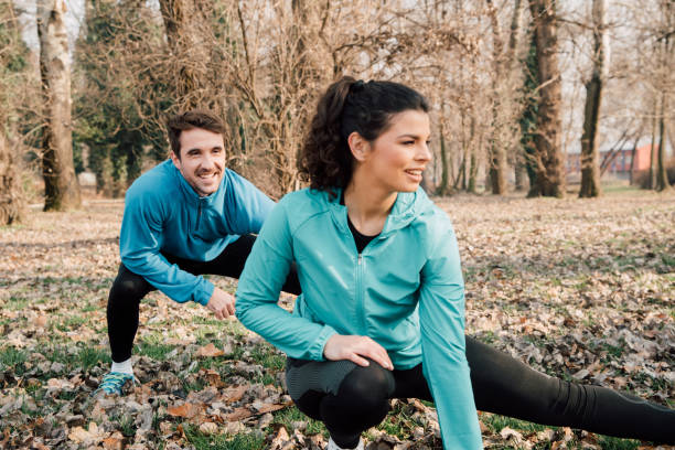 istock Healthy young couple exercising in the park 941724132