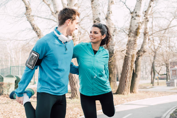istock Athletic couple exercising legs outdoors 941724284