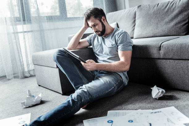 istock Sad moody man sitting on the floor 941727042