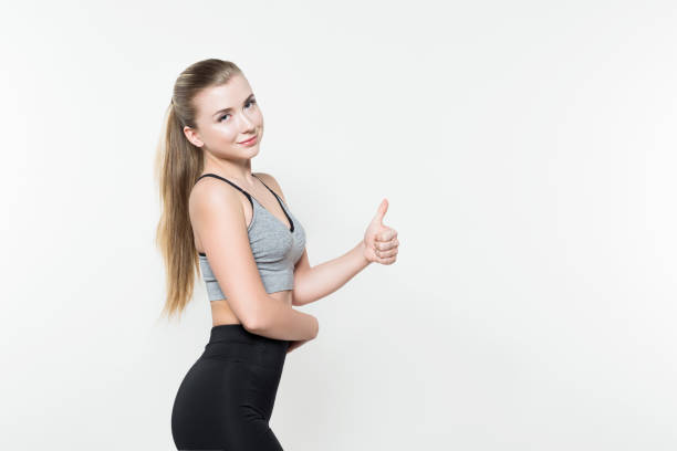 istock Sportswoman showing thumb up isolated on white 941727988