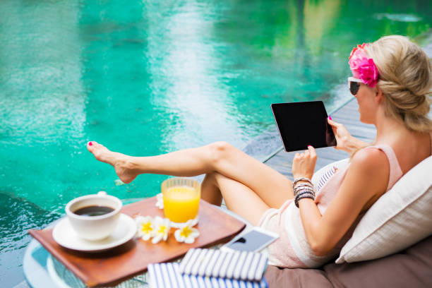 istock Girl with tablet by the pool 941728772