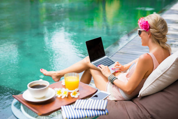 istock Girl working with computer by the pool 941728786