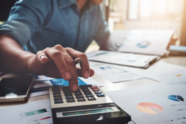 business accounting konzept, geschäftsmann mit taschenrechner mit computer-laptop, budget und leihpapier im büro. - zählen stock-fotos und bilder