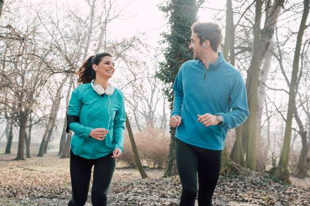 istock Athletic couple running in a park 941730490
