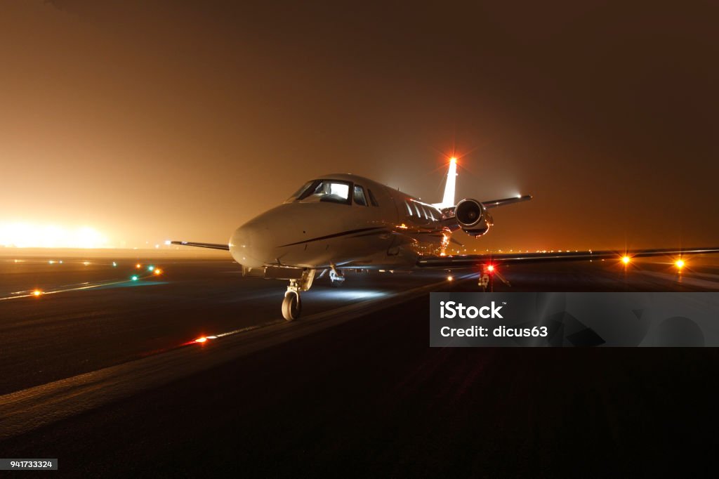 Business jet ready for take off Luxury business jet ready for take off at the runway at night Corporate Jet Stock Photo