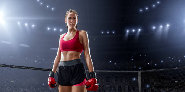 Beautiful female Mixed Martial Arts athlete in boxing gloves in professional ring
