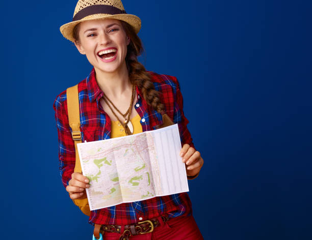 istock smiling fit traveller woman on blue background with map 941737944