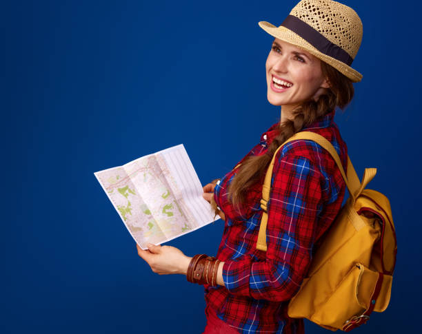 istock tourist woman on blue background with map looking into distance 941738122
