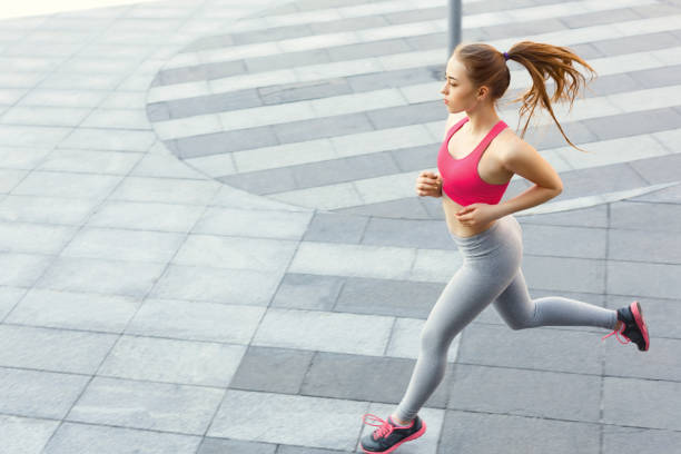 istock Young woman jogging in city copy space 941738222