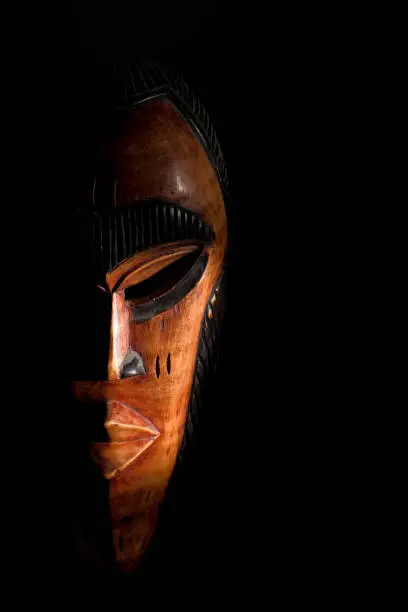 Photo of African mask. Travel souvenirs isolated on black background