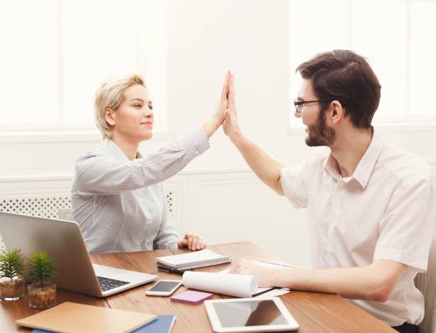istock Young happy business partners in office with computer 941749618