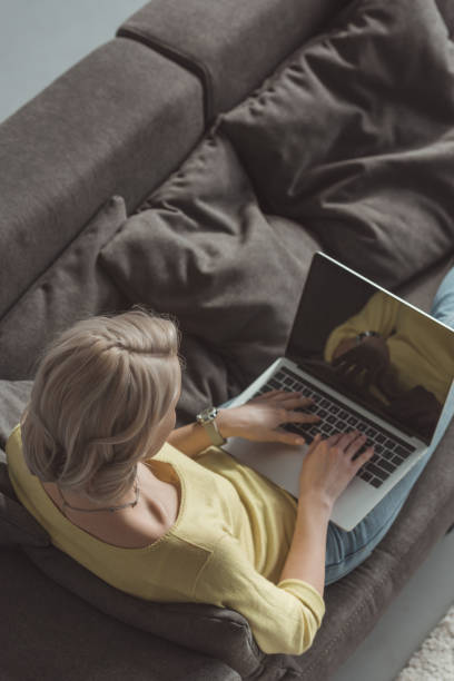 istock high angle view of girl using laptop on sofa 941750140