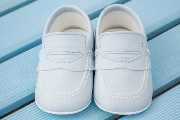 Pair of  classic blue baby shoes over blue background
