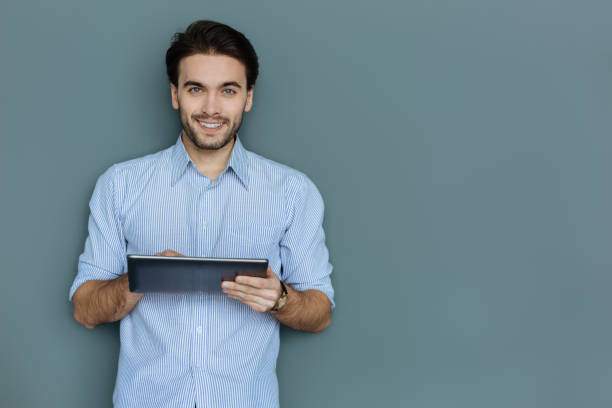 istock Positive attractive man holding a tablet 941758658