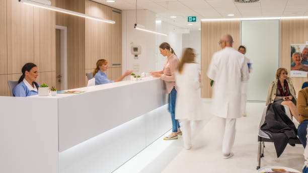 Doctors walking in clinic Blurred motion of doctors walking in clinic, patients sitting on chair. reception desk photos stock pictures, royalty-free photos & images