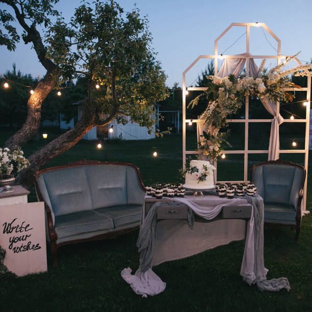 istock beautiful decorative illuminated wedding arch and cake with desserts on table 941762410