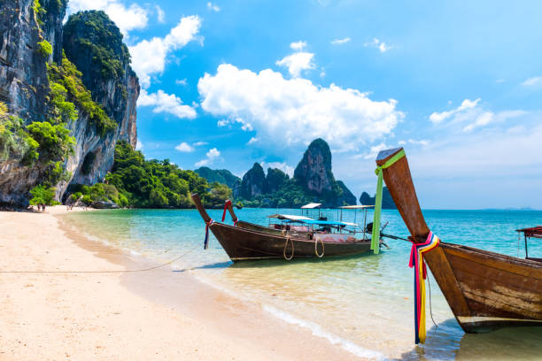 Long tail boat tropical beach, Krabi, Thailand Long tail boat on tropical Railay beach, Aonang, Krabi, Thailand karst formation photos stock pictures, royalty-free photos & images