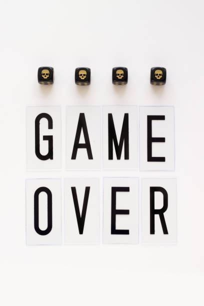istock GAME OVER text and gaming dice with image skull on white background. 941774934