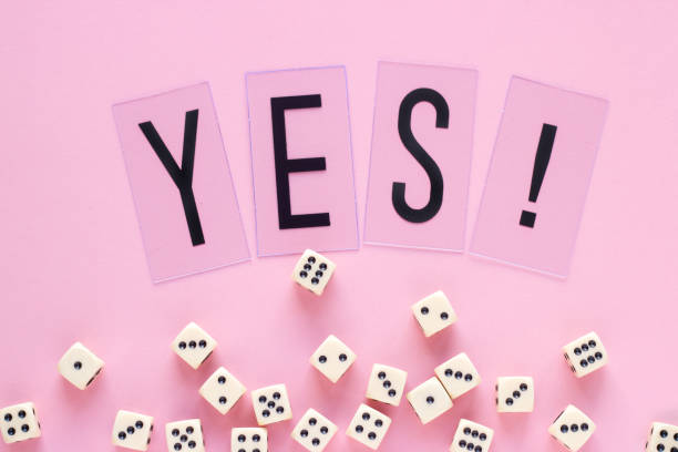 istock Gaming dice with word YES on pink background. 941775100