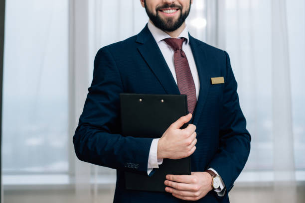istock cropped shot of smiling hotel administrator with clipboard 941775410