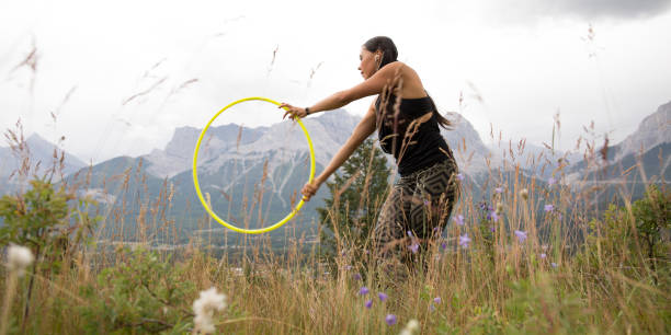 Native American woman dances with hoops, in mountains