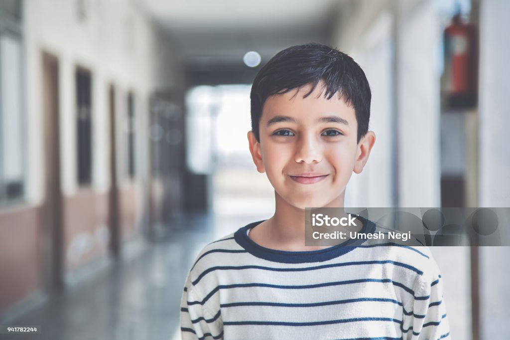 Portrait of a young school boy smiling Close-up portrait of smiling 8-9 years Indian kid, standing straight at school campus in school uniform and looking at camera Child Stock Photo