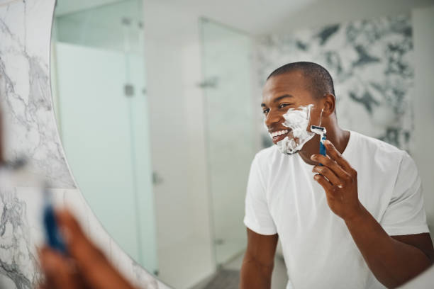 he's not a fan of the face fuzz - shaving men shaving cream mirror imagens e fotografias de stock
