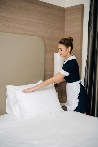 istock young happy maid in uniform making bed at hotel suite 941785596