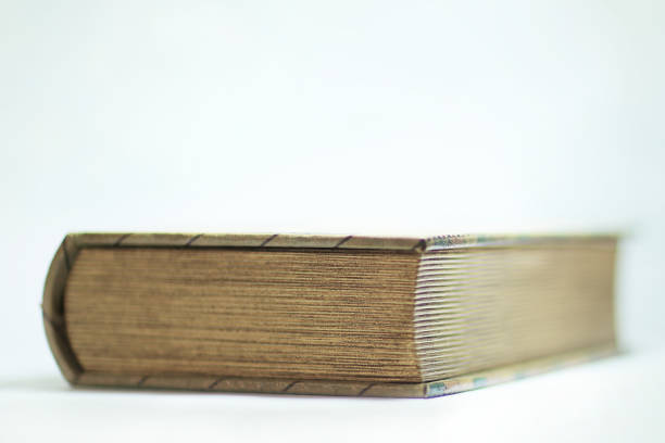 istock close up.thick closed book on white background 941786156