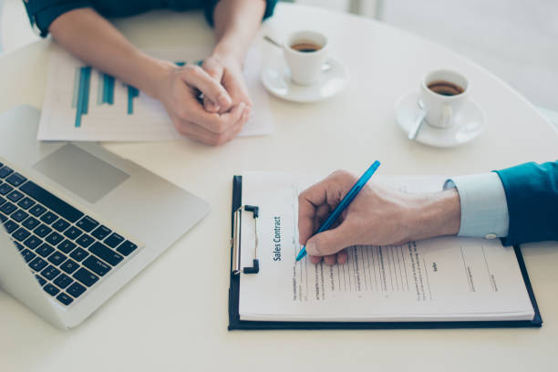 istock Workplace concept. Top view on man's hand holding a pen and signing a contract 941789196