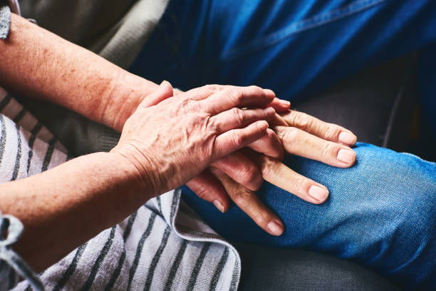 istock Senior couple sitting together holding hands 941789372