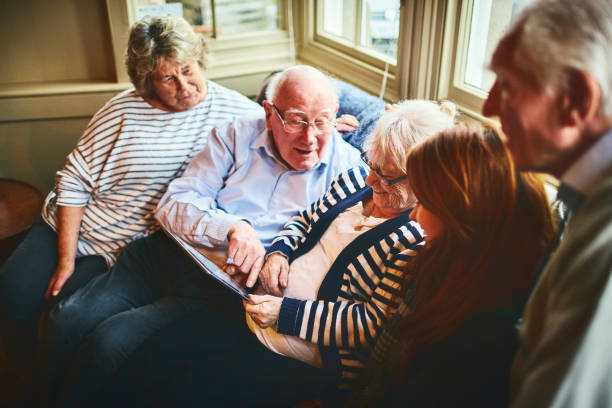Group of elderly people with young woman using digital tablet