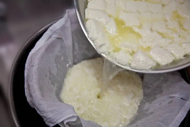 The photography shows the process of making mozzarella cheese, which drains off the whey through a white gauze and remains a chunk of cheese.