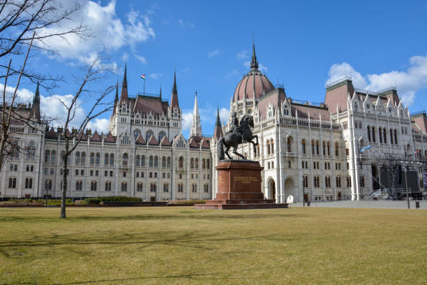 istock The Budapest parliament with a rider statue and blue sky 941808954