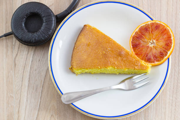 ケーキ、オレンジ色の果物の木のテーブルにヘッドフォンと自家製ケーキの背景コンセプトあなたのフリータイムでリラックスを。 - italian dessert audio ストックフォトと画像