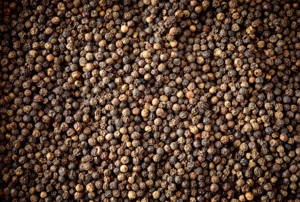 istock Peppercorn background. Dry black pepper seeds. Top view. 941825746