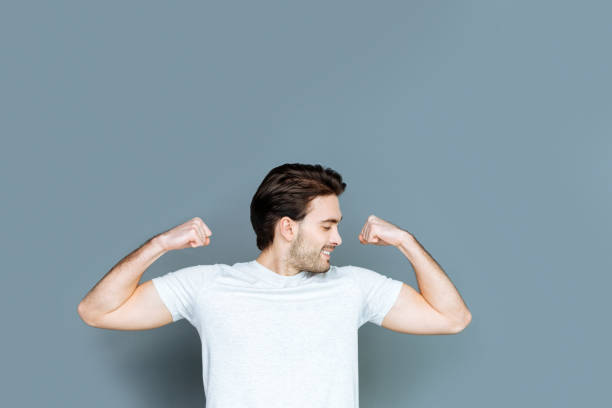 istock Happy well built man looking at his muscles 941825832