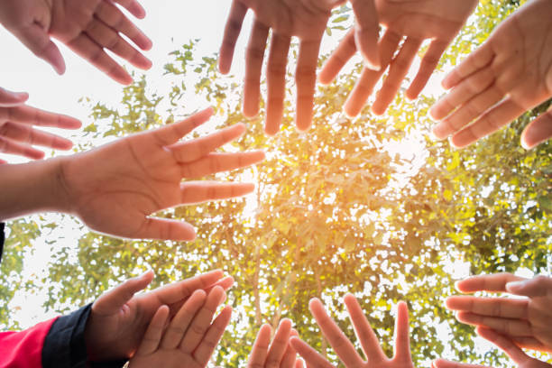 istock Unity and teamwork Concept: Blurred of Group students hands together in activities outdoor classroom. View of Asian young childrens putting hand together show teamwork to success learning in school 941829790