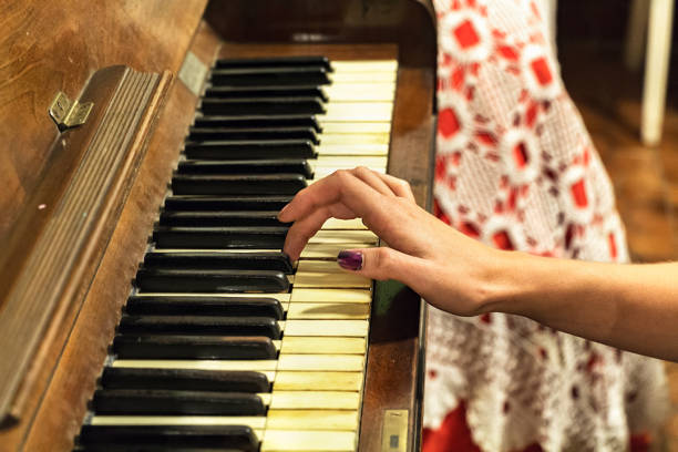 istock A female hand playing an old vintage piano. 941830944