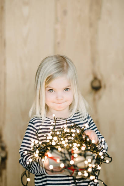 istock Cute little girl with Christmas lights 941834236