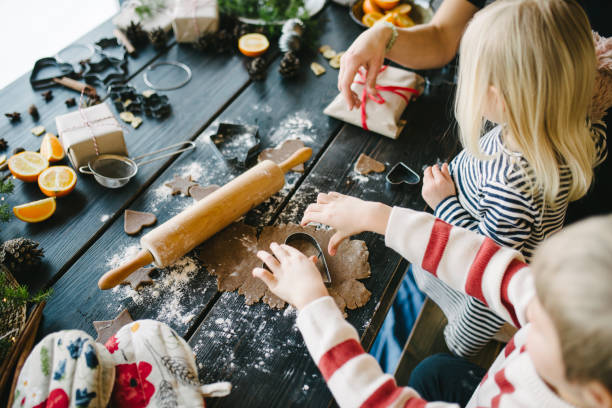 escandinava familia hacer galletas de jengibre para navidad - christmas child cookie table fotografías e imágenes de stock