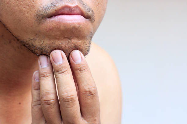 istock Close-up of young bearded man touching his beard on white background 941834992