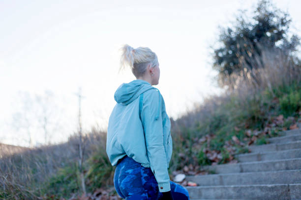 istock Active cheerful blonde pausing after a run in a park on a sunny day 941842422