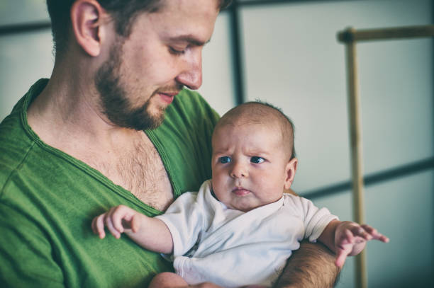 istock father holding his newborn baby son at home. 941843384