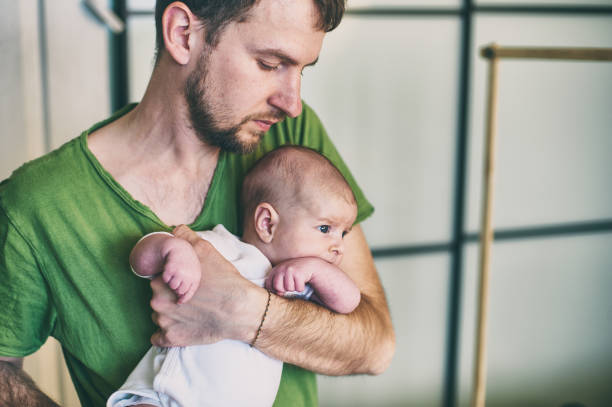 istock father holding his newborn baby son at home. 941843386