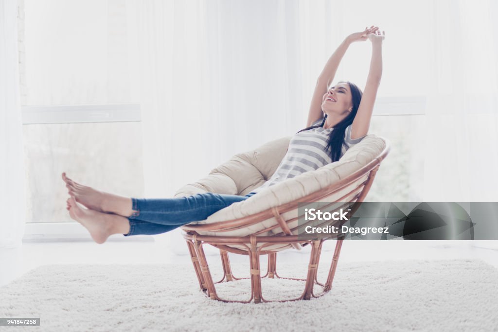 Good day! Happy cute pretty woman lying in the armchair on the weekend and stretching Women Stock Photo