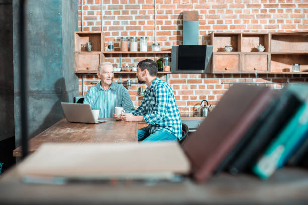 istock Positive nice father and son sitting in the kitchen 941847674