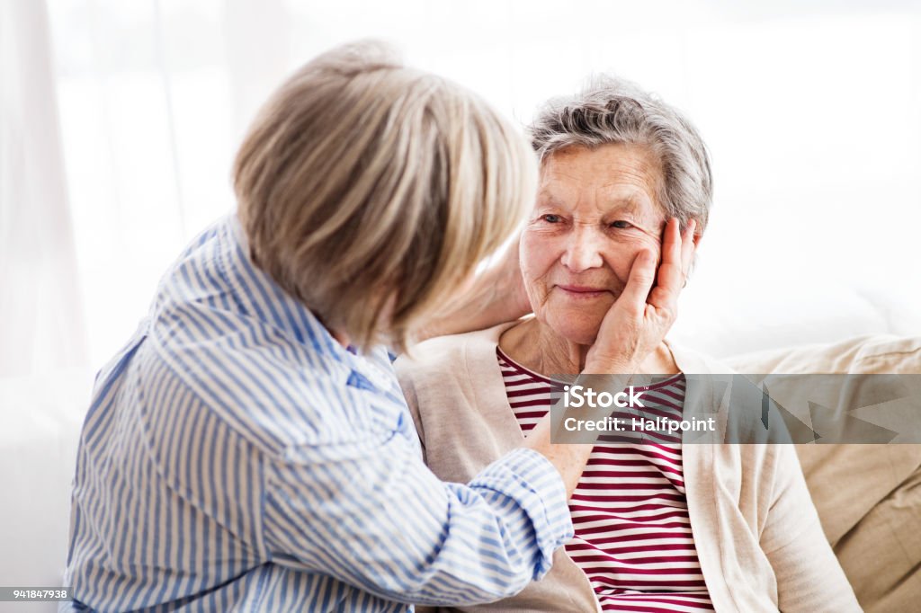 Senior women at home. Two senior women at home, hugging. Family and generations concept. Adult Offspring Stock Photo