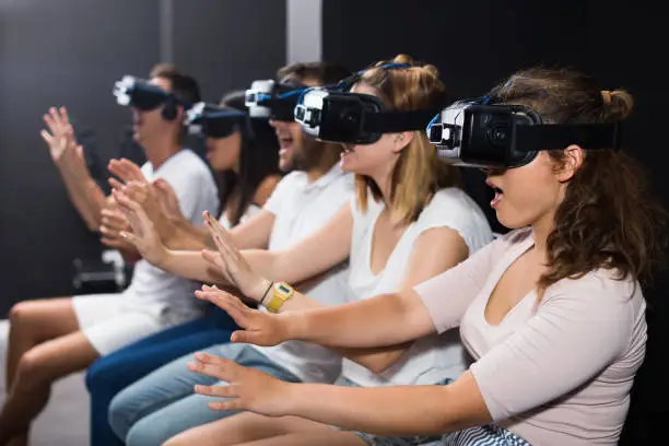 Photo of scared girl on virtual reality attraction sitting with another people