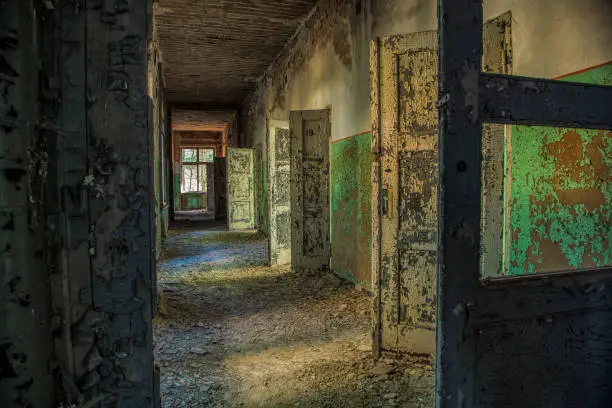 A long corridor with many open doors of a lost place
